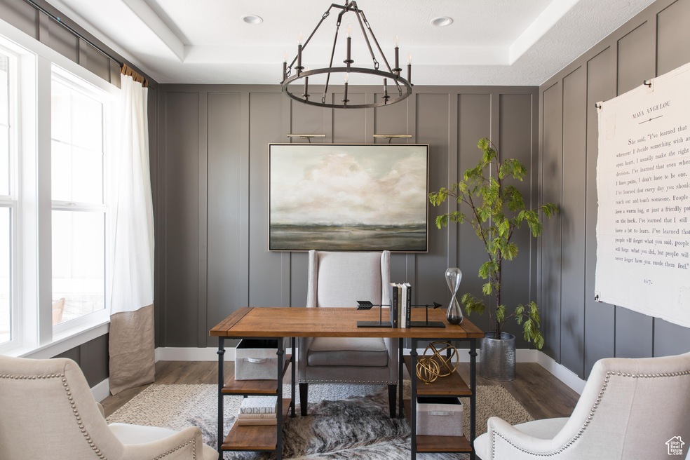Office with a tray ceiling, hardwood / wood-style floors, and a notable chandelier