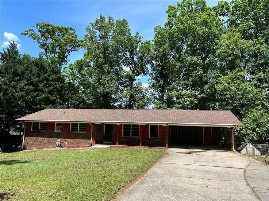 Single story home with a front yard and a carport