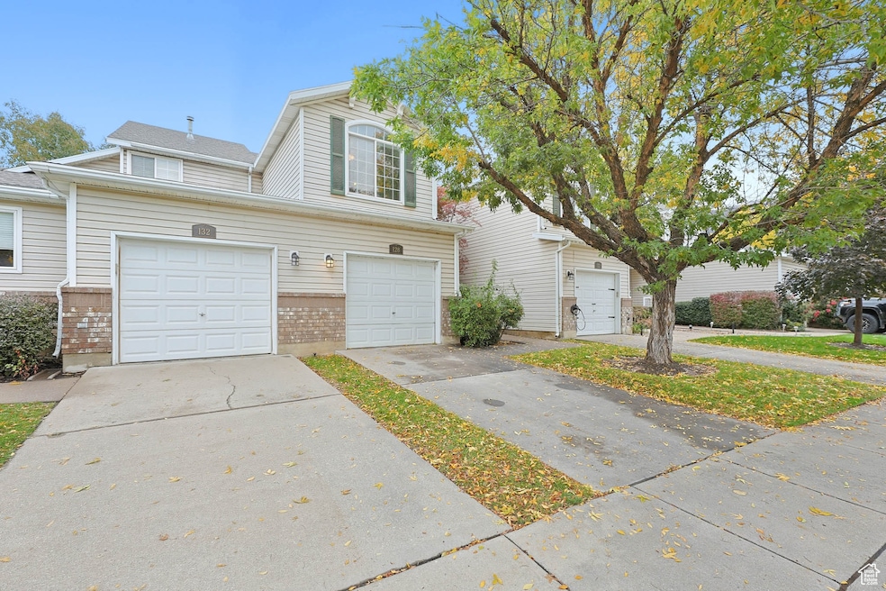 Traditional-style home featuring brick siding, concrete driveway, and a garage