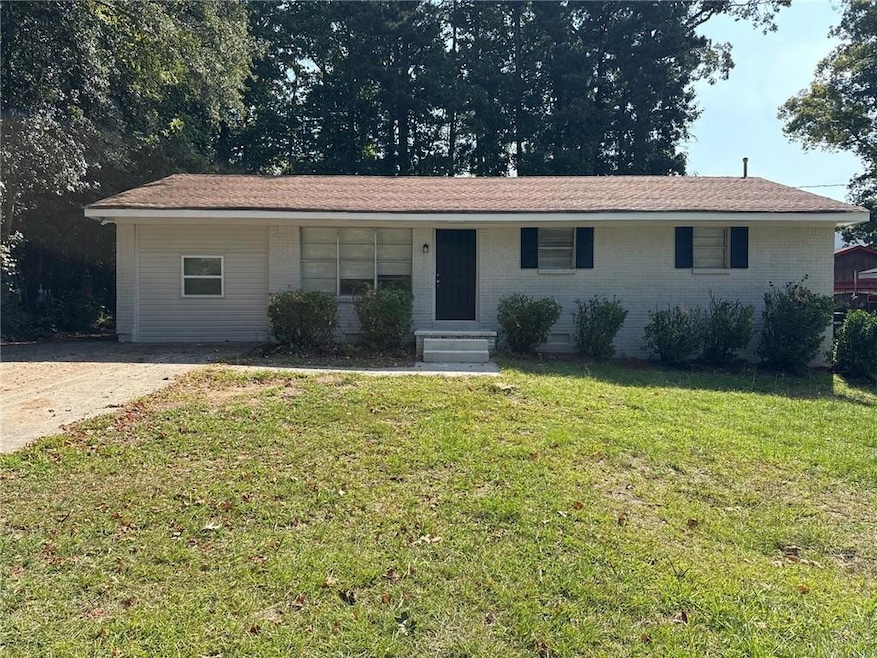 Ranch-style house featuring brick siding, a front yard, and covered porch
