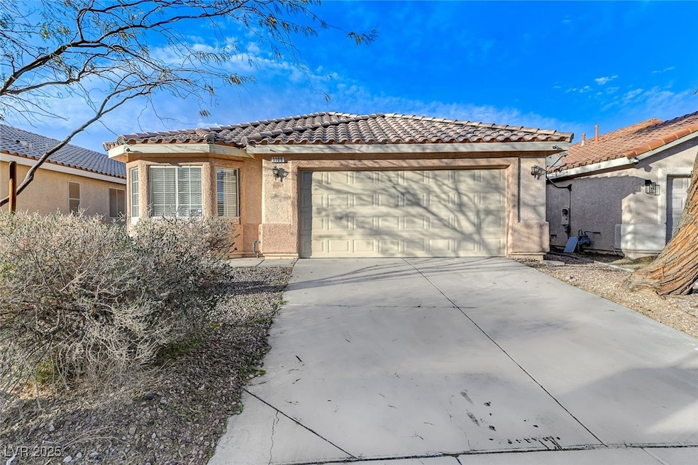 View of front of home featuring a tile roof, a gar