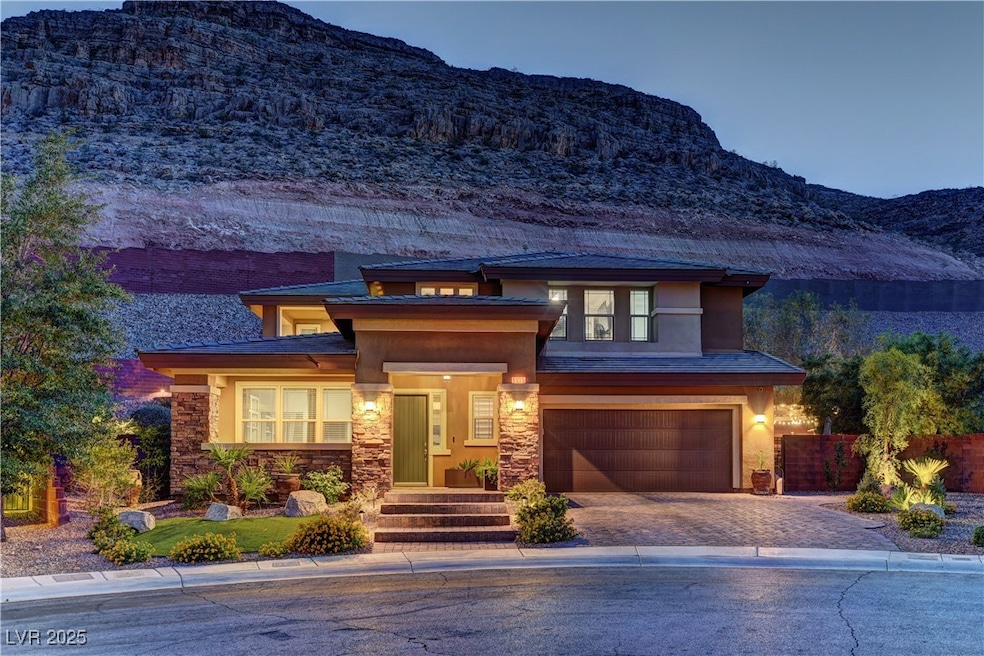 Prairie-style house featuring stone siding, a moun