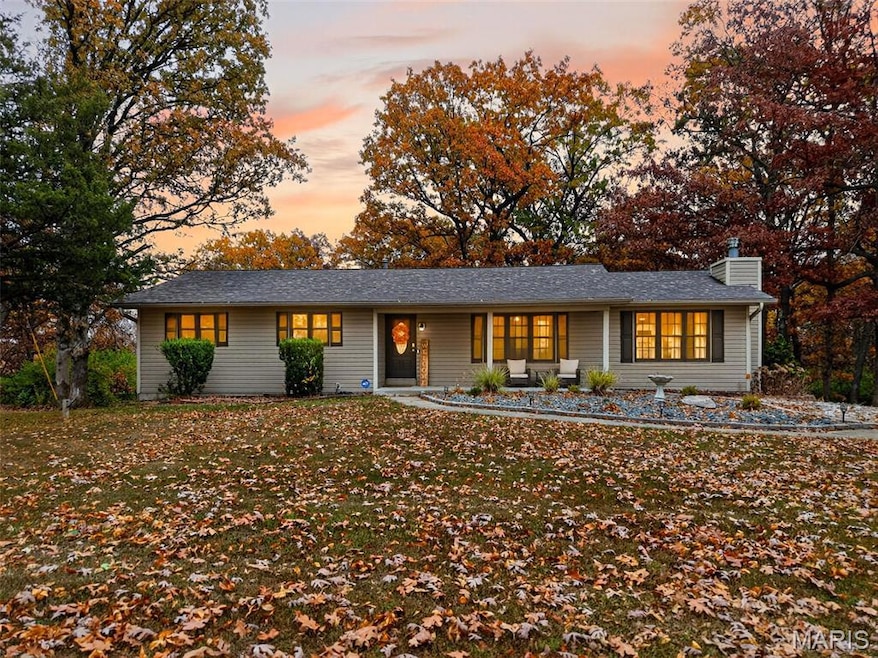 Ranch-style house featuring a porch and a chimney