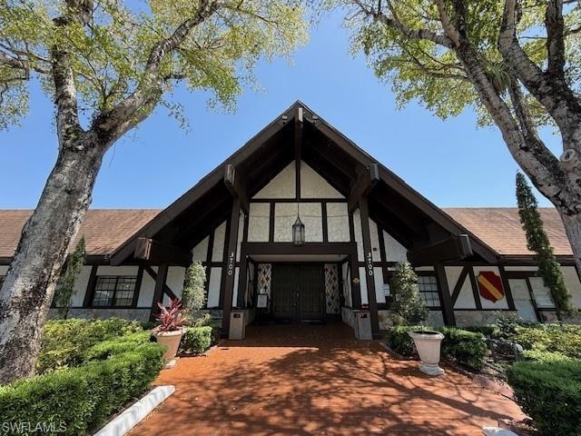 English style home featuring stucco siding and stone siding