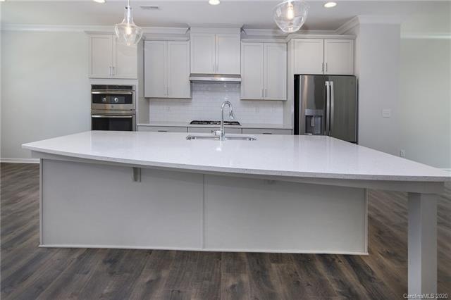 Light and bright gourmet kitchen with gray cabinet