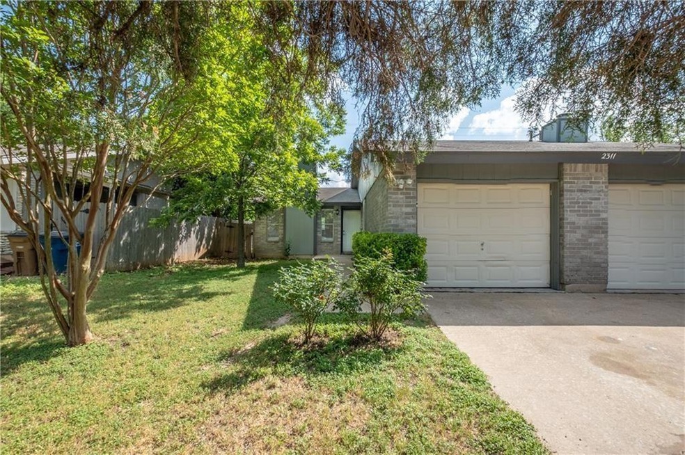 View of front facade with concrete driveway, bric