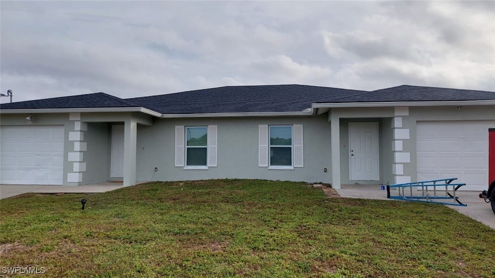 View of front facade featuring a garage, stucco si