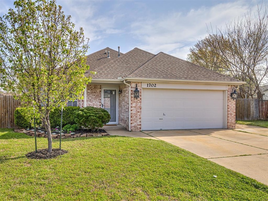 Ranch-style house with driveway, an attached garage, fence, and brick siding