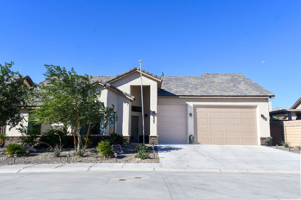 View of front facade with stucco siding, driveway, and a garage