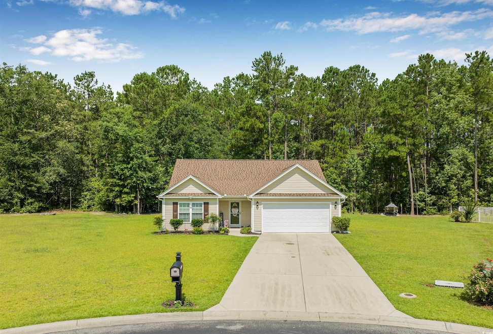 View of front of house with an attached garage, concrete driveway, and a front lawn