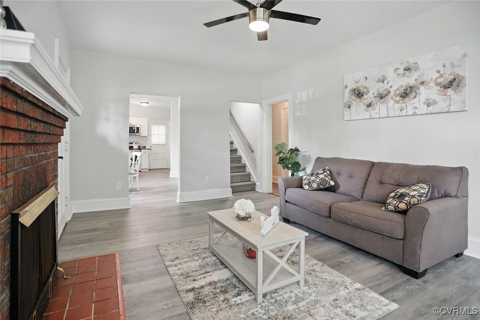 Living area with a brick fireplace, ceiling fan, s