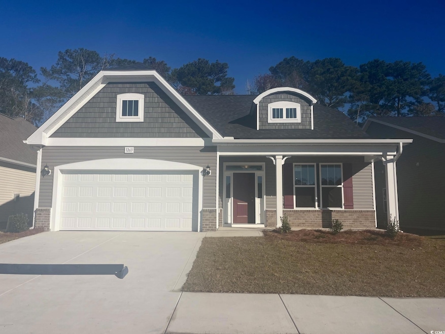 Craftsman house with a porch, brick siding, concrete driveway, and a garage