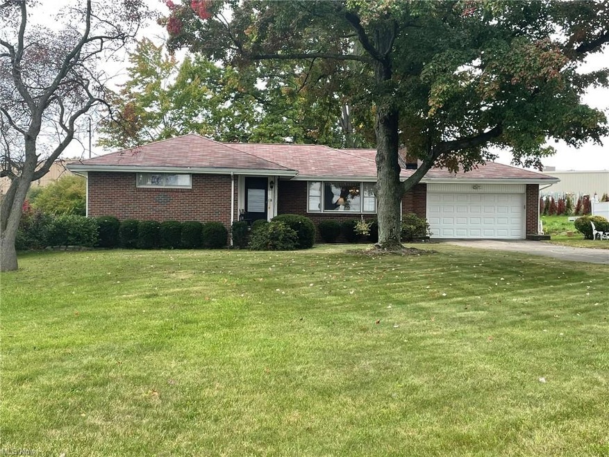 Ranch-style home with a front yard and garage
