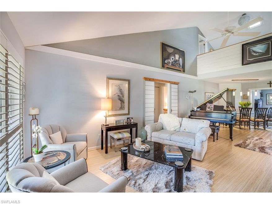 Living room features vaulted ceilings and wood flo