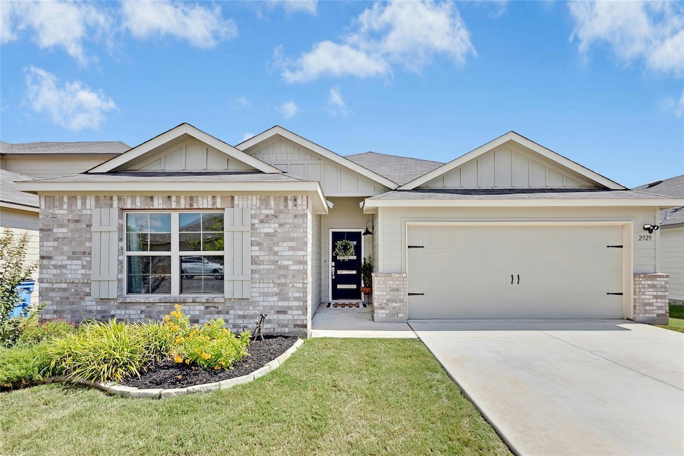 View of front facade featuring brick siding, board and batten siding, concrete driveway, and an attached garage