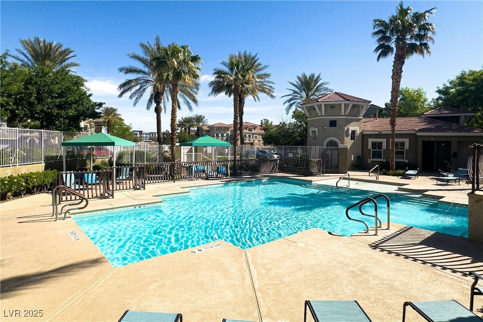 Community pool with a patio and fence