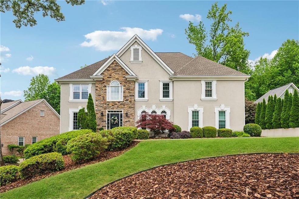 Colonial-style house with stucco siding, stone sid