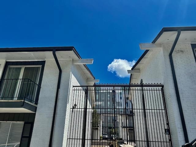 View of home's exterior featuring fence, brick si