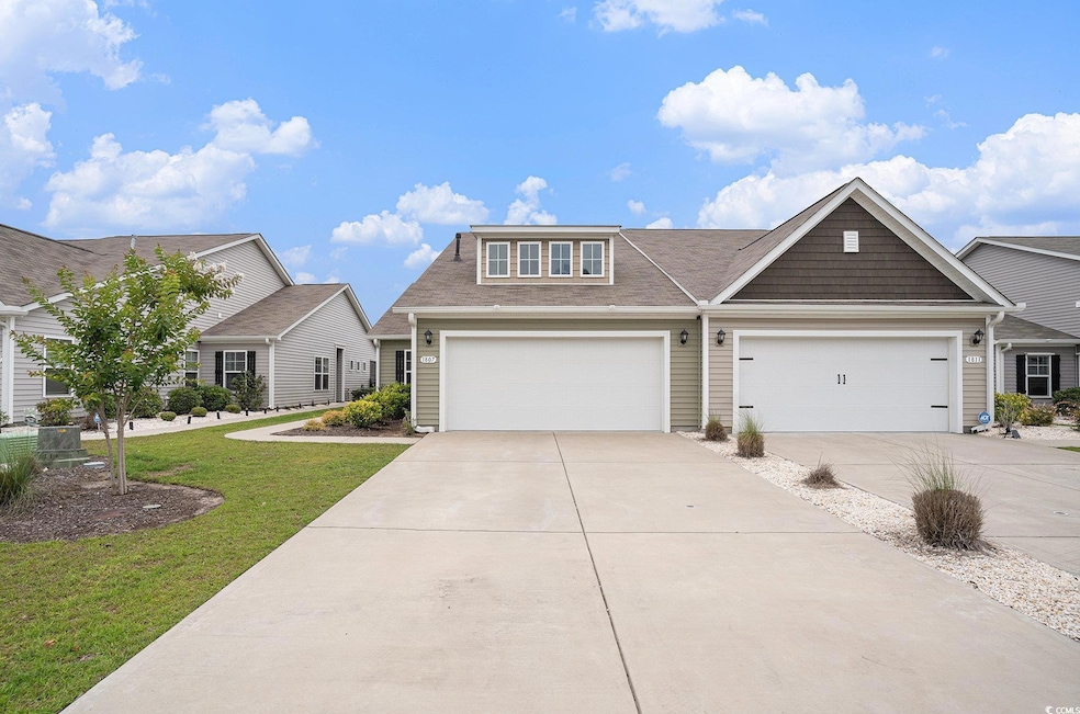 View of front of house with concrete driveway, a front yard, and a shingled roof
