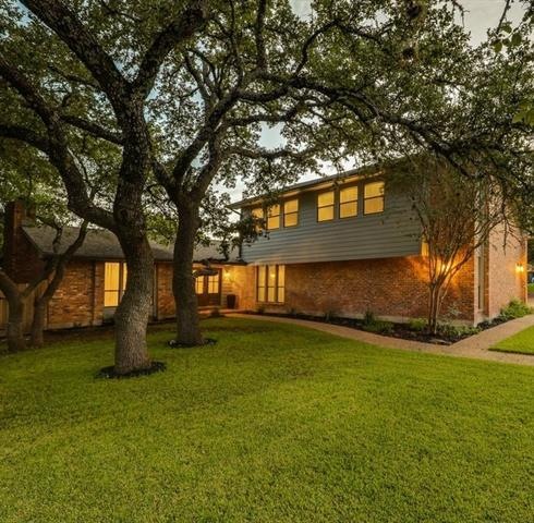 Beautifully landscaped front yard with large oak t