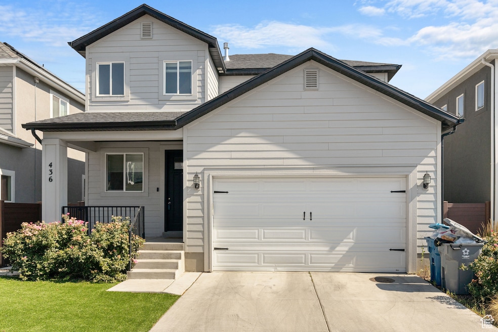 View of front facade featuring covered porch, concrete driveway, an attached garage, roof with shingles, and a front yard
