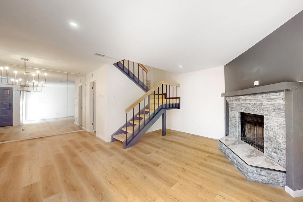 Unfurnished living room featuring a stone fireplac