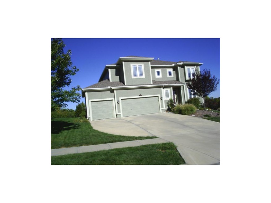 Front of home is all stucco and three car drive.
