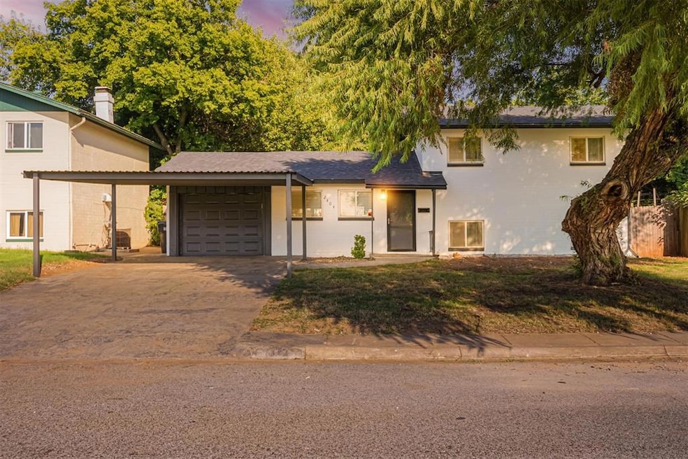 Split level home with driveway, an attached garage, and a front yard