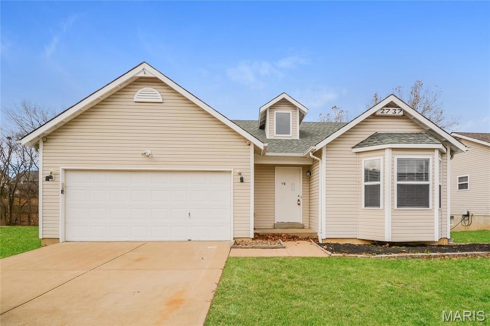 View of front of home with a shingled roof, driveway, an attached garage, and a front yard