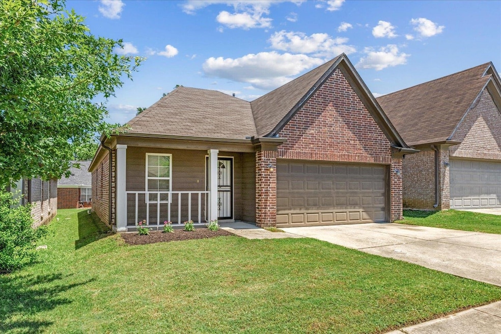 View of front of home featuring brick siding, a garage, a front yard, and concrete driveway