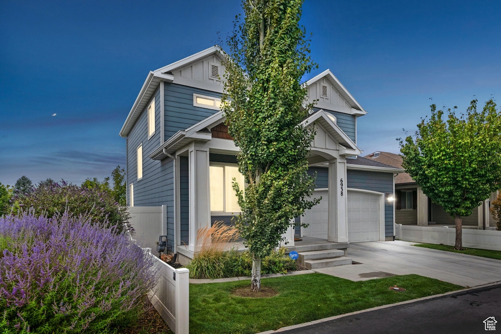 View of front of property featuring a garage, driveway, and board and batten siding