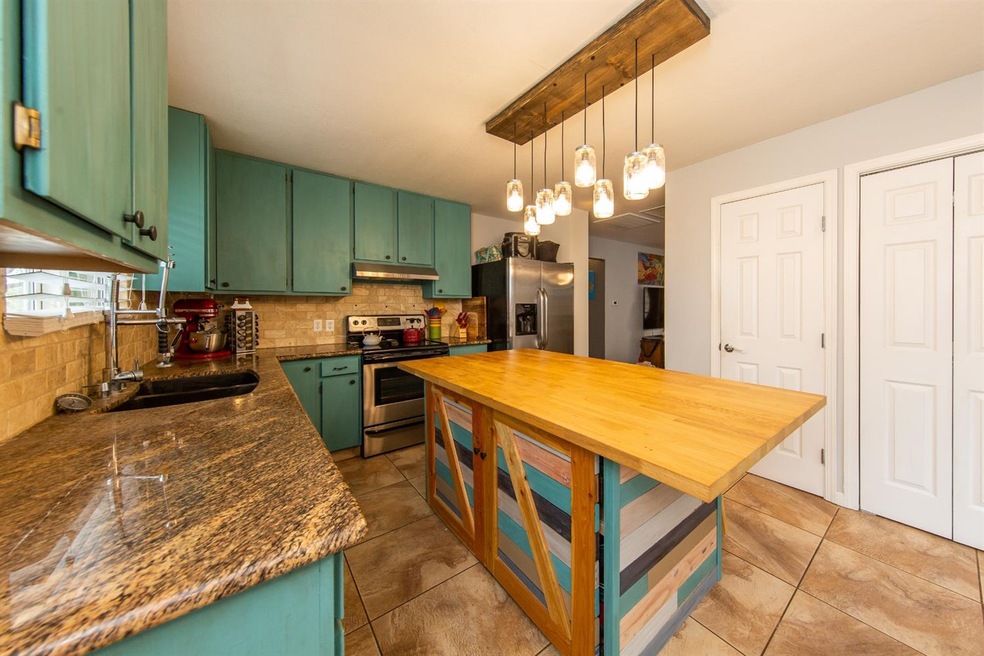 Custom kitchen with granite and island provides lo