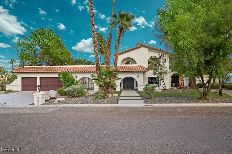 Mediterranean / spanish-style house with a tiled roof, stucco siding, concrete driveway, and an attached garage