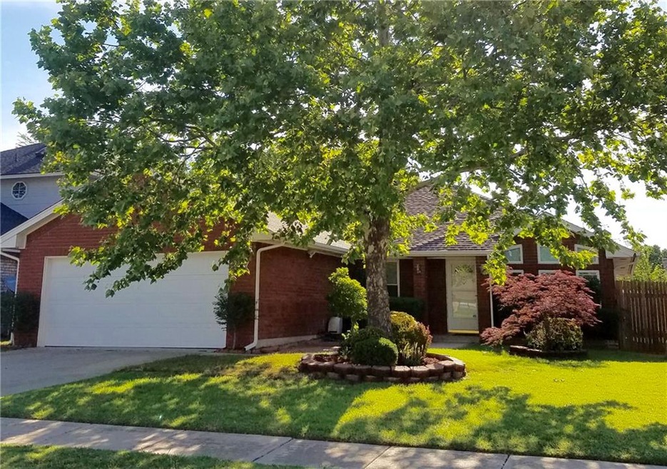 Beautifully landscaped front yard with large matur