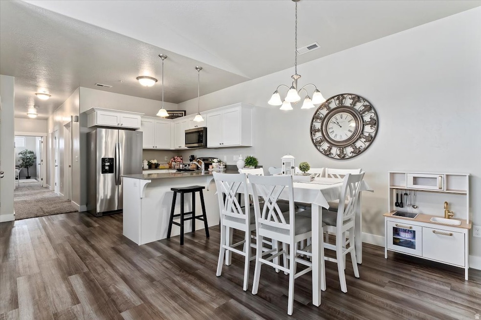 Dining room with dark wood-style flooring and a chandelier