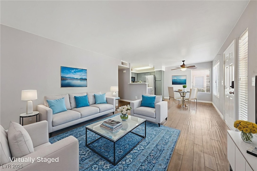 Living room featuring ceiling fan and light wood-s