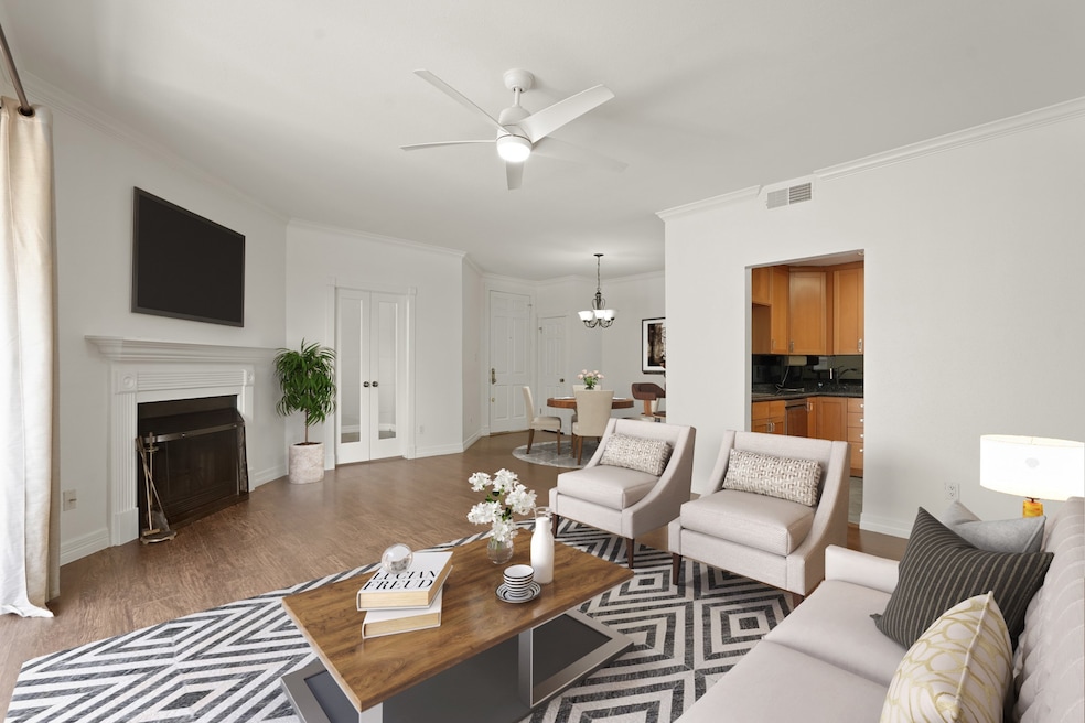This primary bedroom has wood floors, a ceiling fa