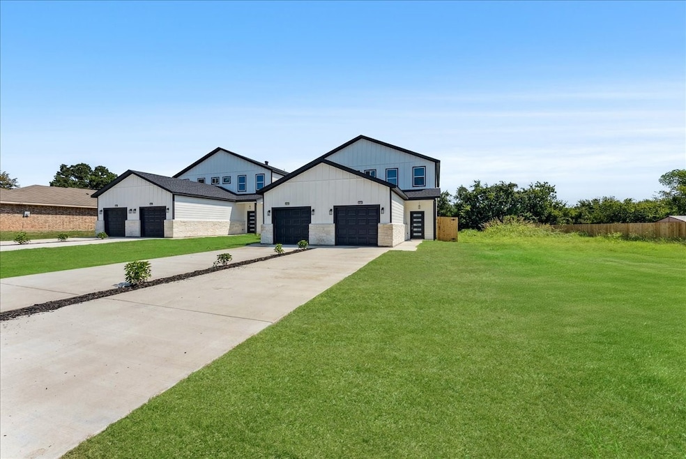 Modern farmhouse style home with a front lawn, a garage, stone siding, and concrete driveway