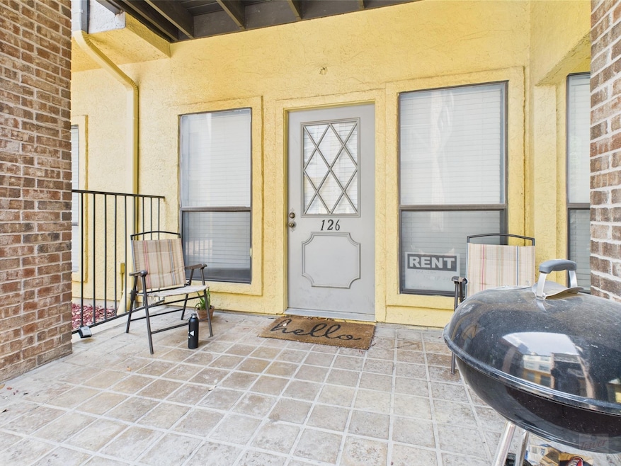 Property entrance featuring stucco siding and bri