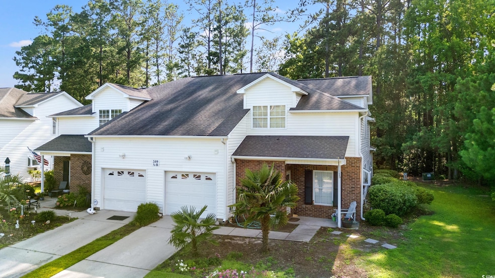 Traditional-style house with concrete driveway, an attached garage, brick siding, a front lawn, and a shingled roof