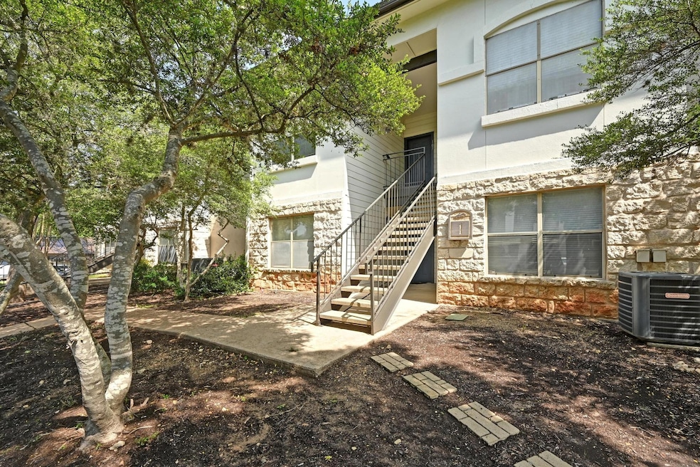 View of exterior entry with central AC and stone 