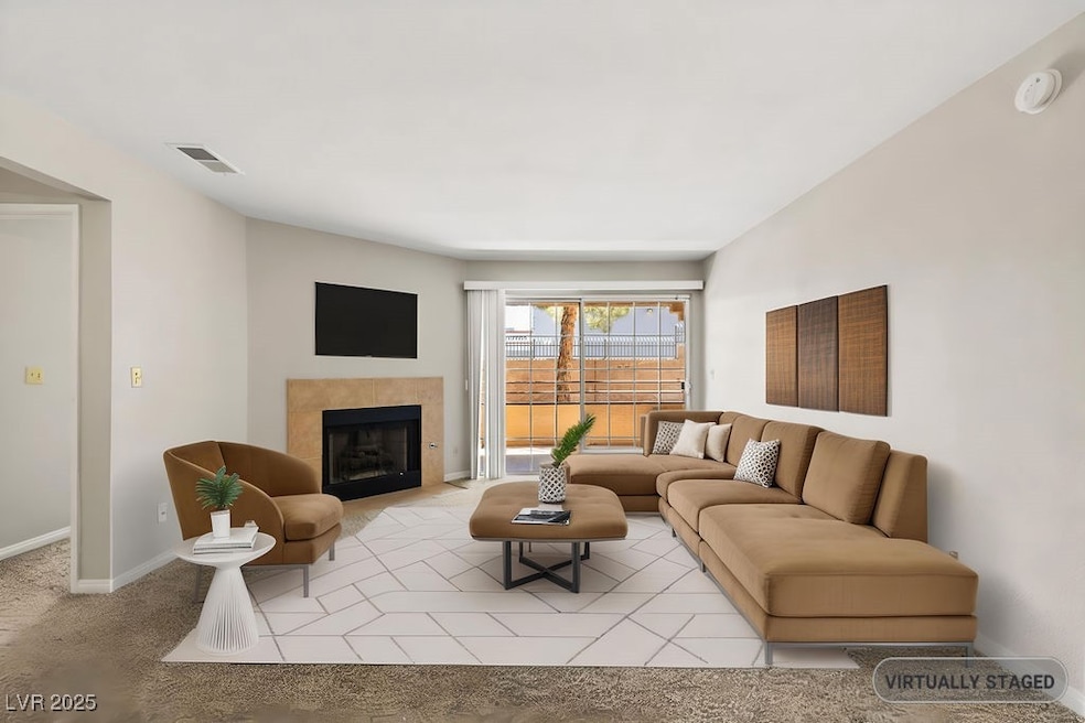 Living area featuring baseboards, a tile fireplace