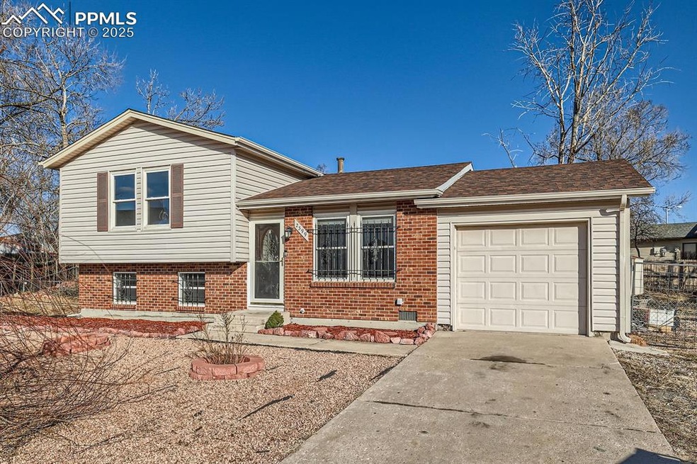 Split level home with brick siding, driveway, a ga