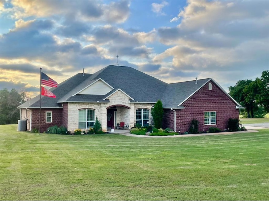 View of front of property with a front lawn, a shingled roof, and brick siding