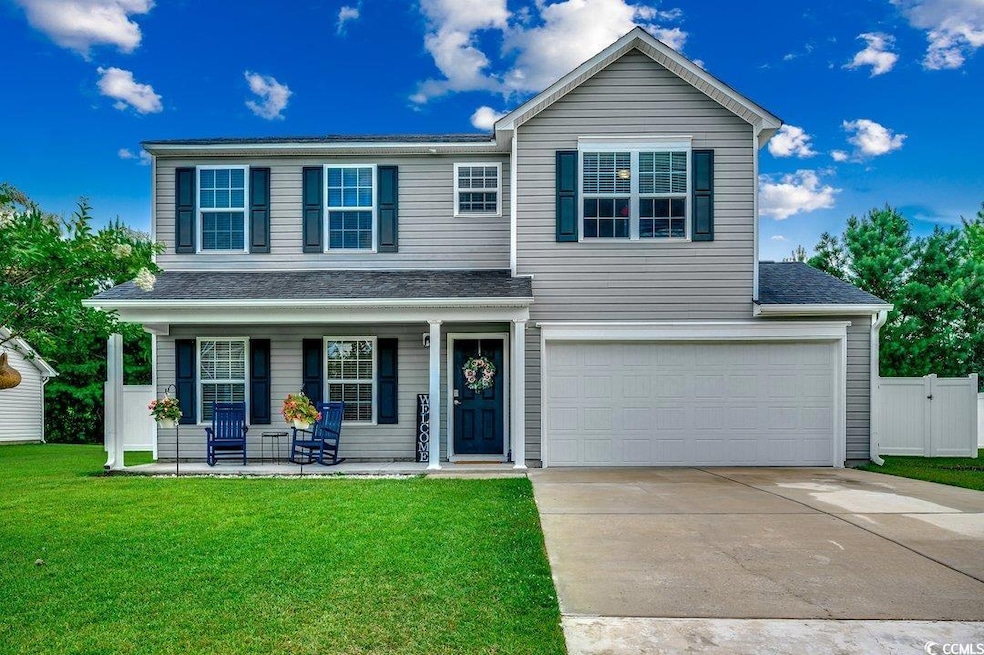 Traditional-style house featuring a porch, driveway, an attached garage, and a shingled roof
