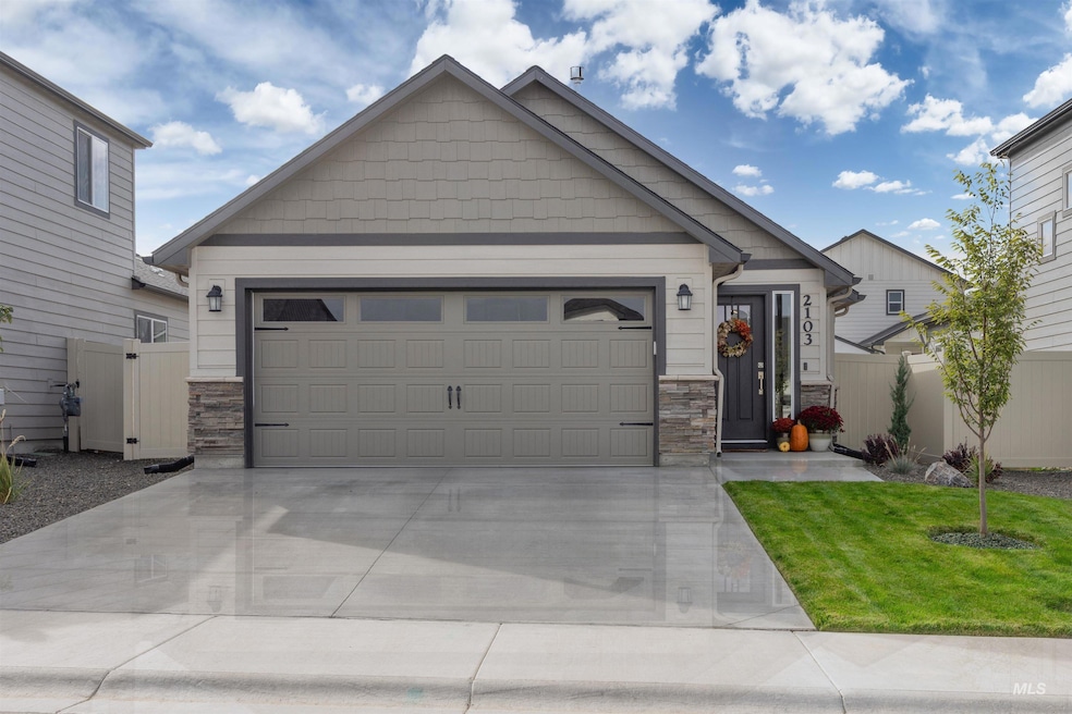 Craftsman inspired home featuring stone siding, driveway, and a garage