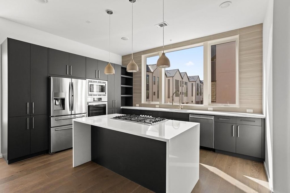 Kitchen with stainless steel appliances, wood fin