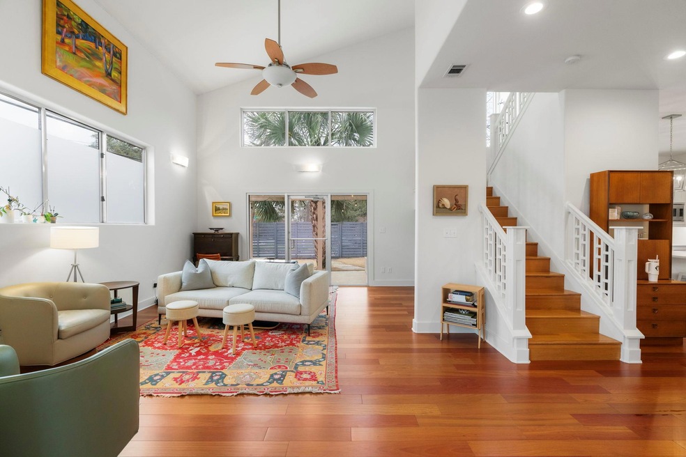 Living area with visible vents, a ceiling fan, wo
