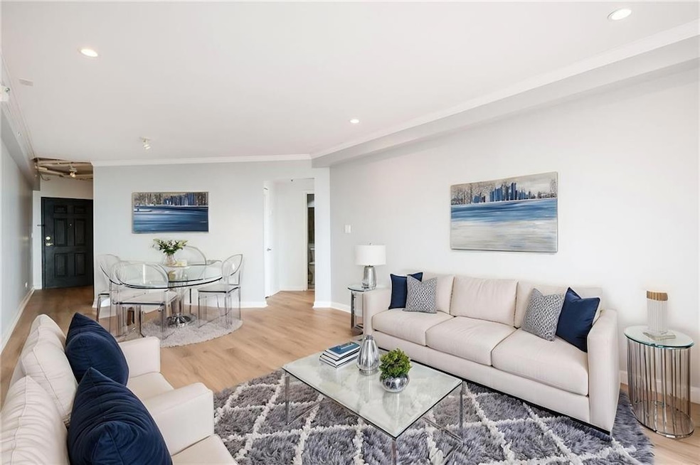 Living area with wood finished floors, recessed lighting, baseboards, and crown molding, recessed lighting