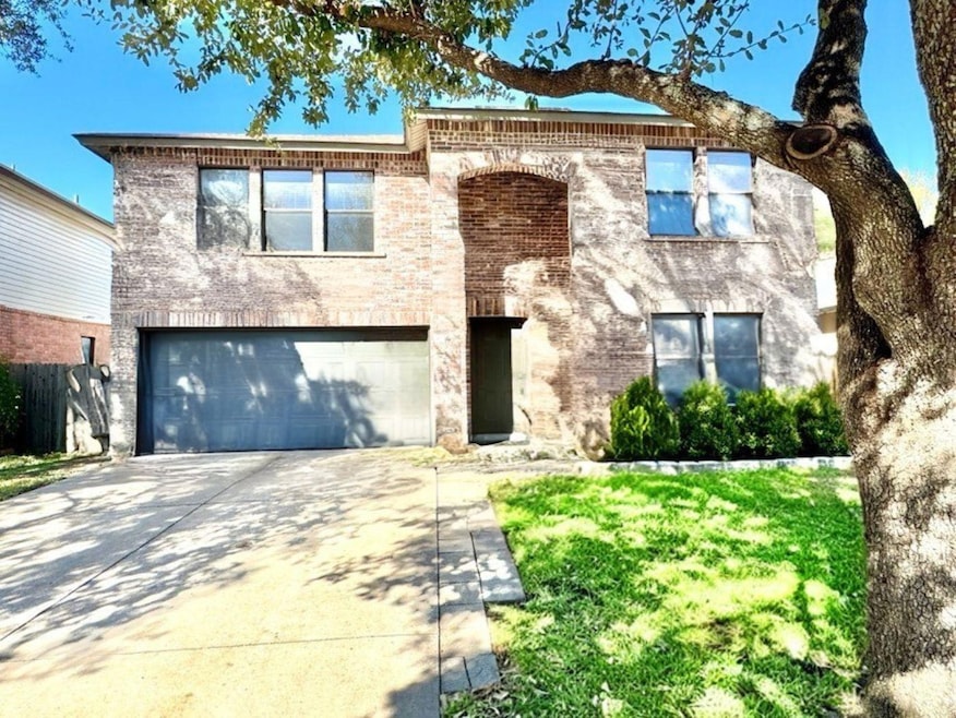 View of front facade featuring concrete driveway, an attached garage, and brick siding
